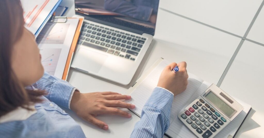 close up of women writing in a journal