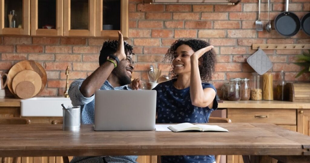 couple high fiving over saving money