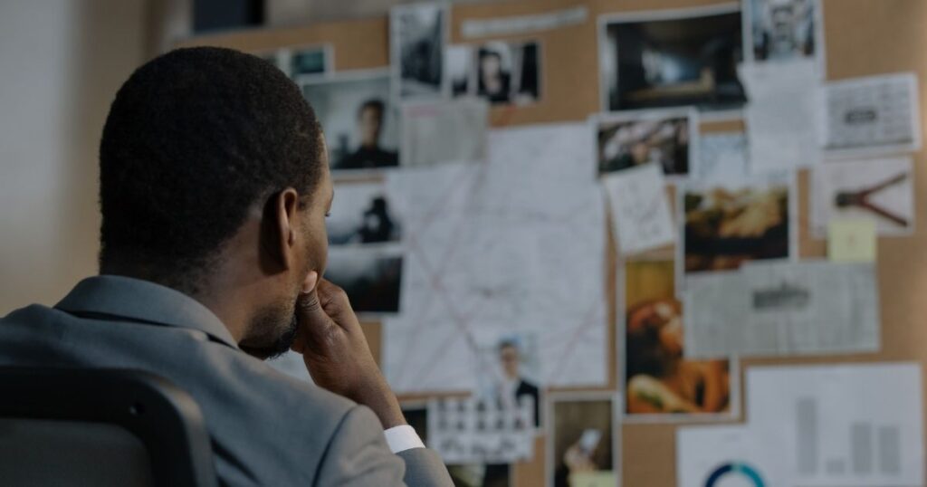 man viewing items pinned on office corkboard